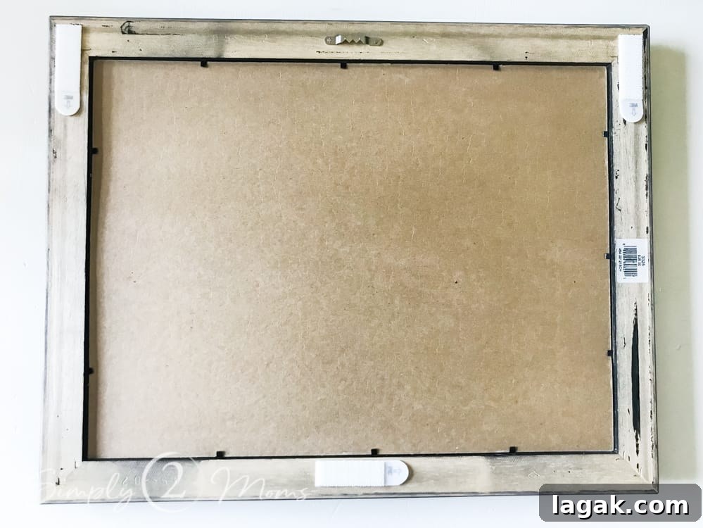 back of picture frame with three command strips attached to edges of frames