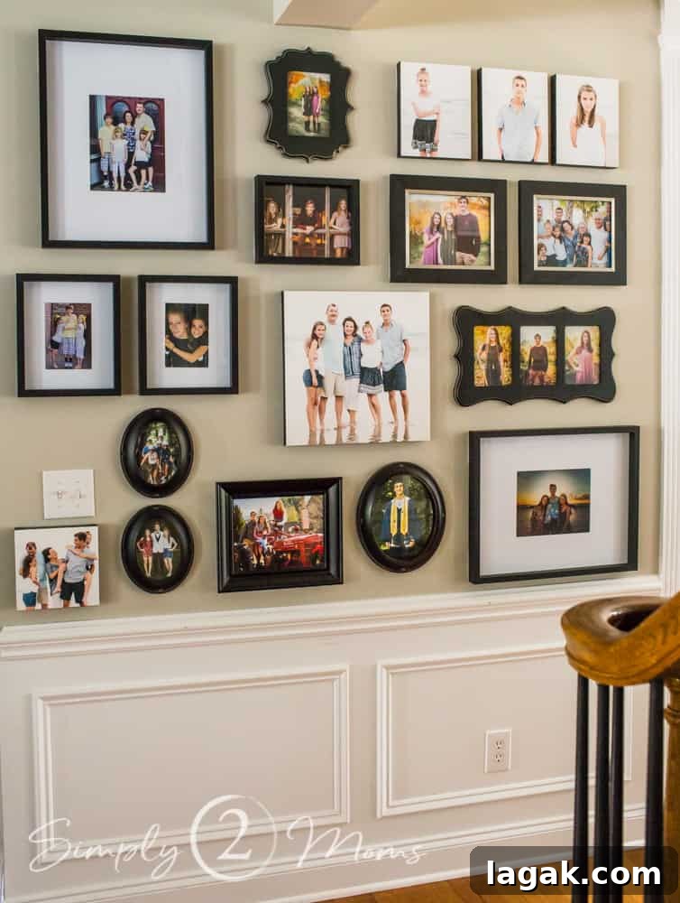 front entry gallery wall of family photos in a variety of black frames mixed with gallery-wrapped canvas prints with black borders
