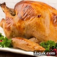 Buttermilk and Honey Brined Roast Turkey Recipe 4 An uncarved buttermilk and honey brined turkey with crisp, golden brown skin and a garnish of parsley and fresh cranberries.