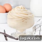 Bavarian Cream Recipe: Silky Crème Bavaroise Made at Home 9 Cream piped in a glass cup surrounded by vanilla bean, eggs and milk.