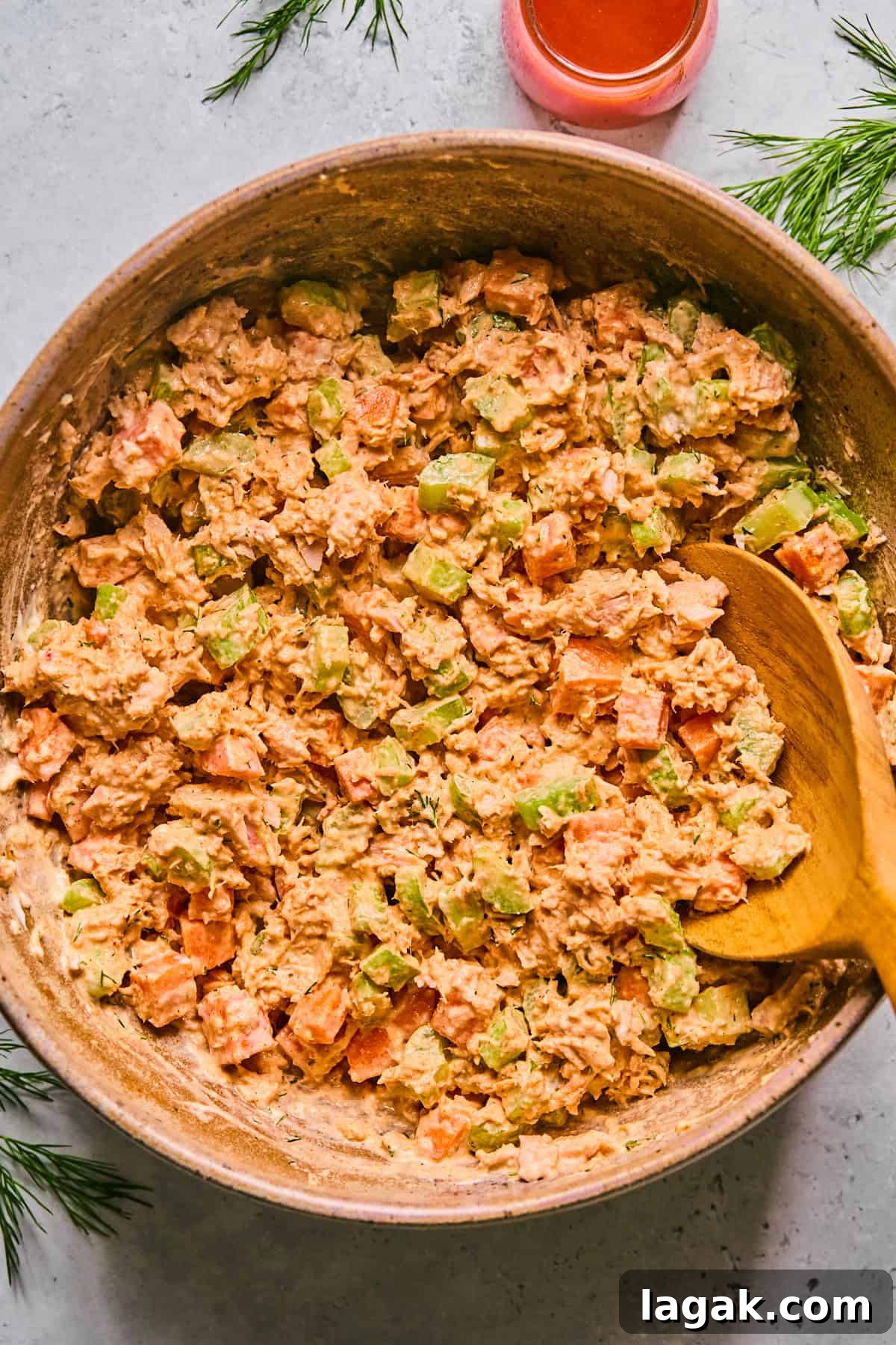 High-Protein Buffalo Tuna Salad Recipe for Meal Prep 5 buffalo tuna salad in a pink bowl with a wooden spoon