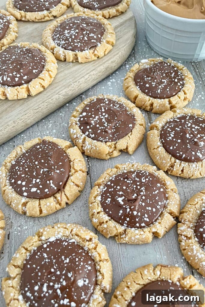 Muddy Buddy Cookie Recipe: No-Bake Peanut Butter Chocolate Treat 2 Muddy Buddy Cookies laid out flat with creamy peanut butter on the side