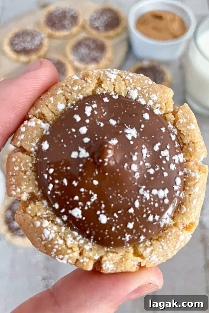 Muddy Buddy Cookie Recipe: No-Bake Peanut Butter Chocolate Treat 3 Close up photo of a single muddy buddy cookie being held between two fingers.