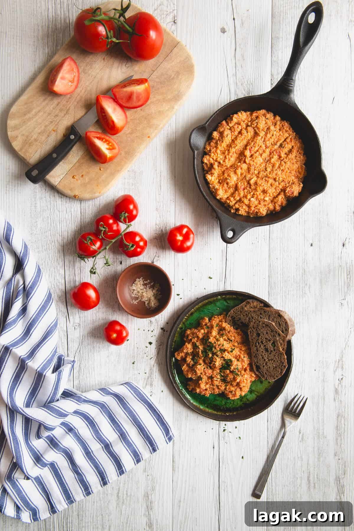 Strapatsada (Kagianas): Classic Greek Tomato Scrambled Eggs Recipe 9 Overhead view of Greek strapatsada served with rustic bread and fresh tomatoes on a wooden table.