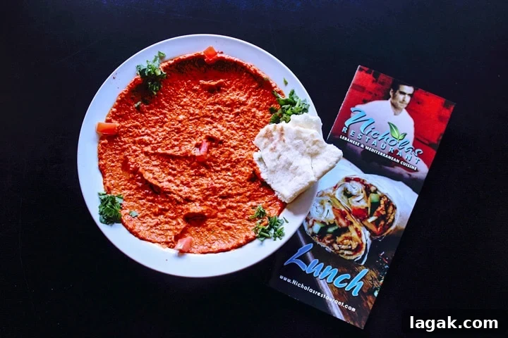 Top Portland Lunch Spots for Spring & Summer 2022 9 roasted red pepper and walnut hummus on a plate with pita bread and a nicholas restaurant menu