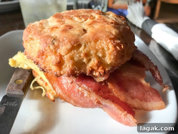 Top Portland Lunch Spots for Spring & Summer 2022 19 Hazel Room biscuit sandwich with bacon and scrambled egg on a white plate