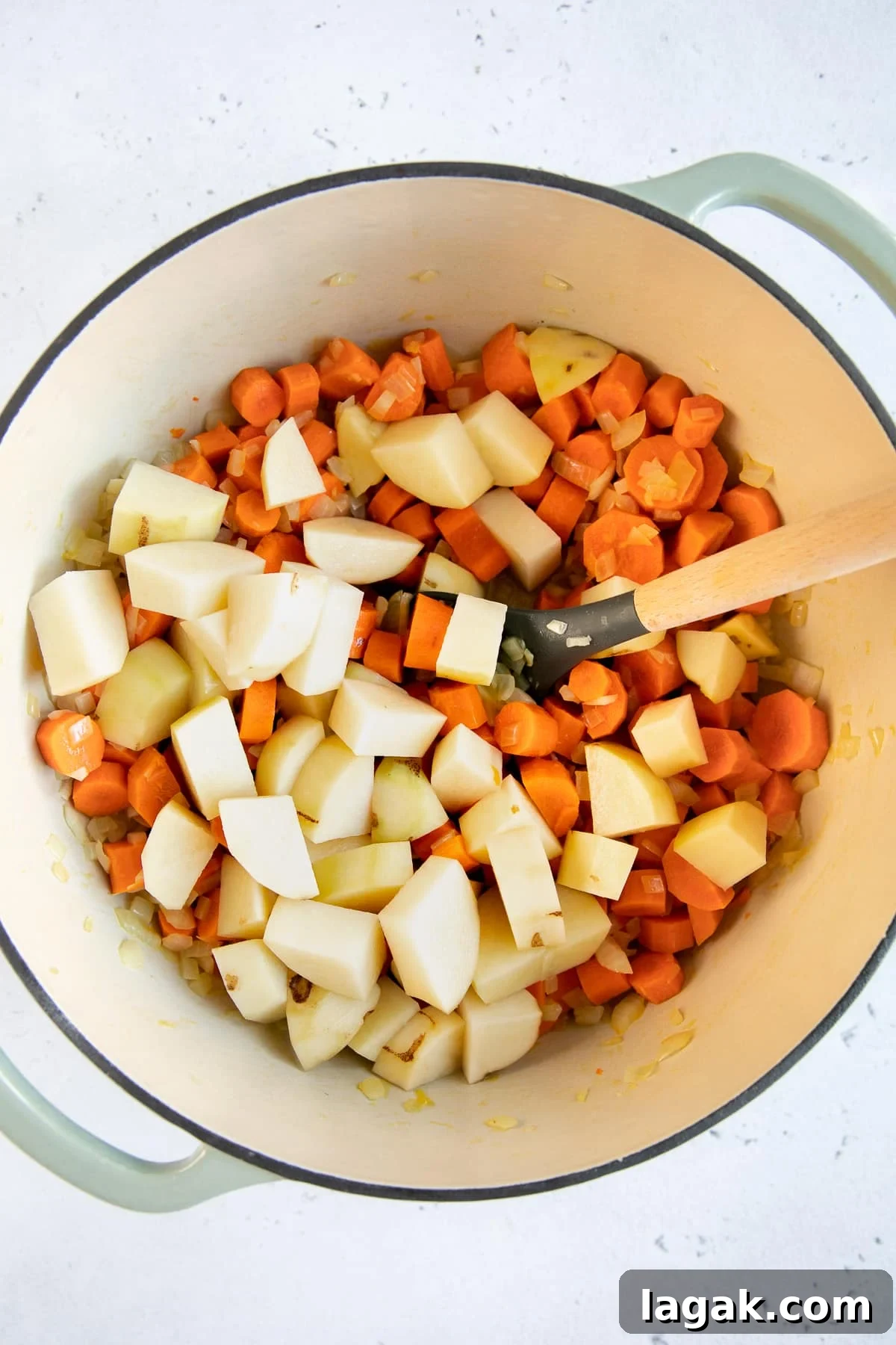 Creamy Carrot and Ginger Soup Recipe for Cozy Comfort 4 Large Dutch oven filled with cooking carrots and potatoes.
