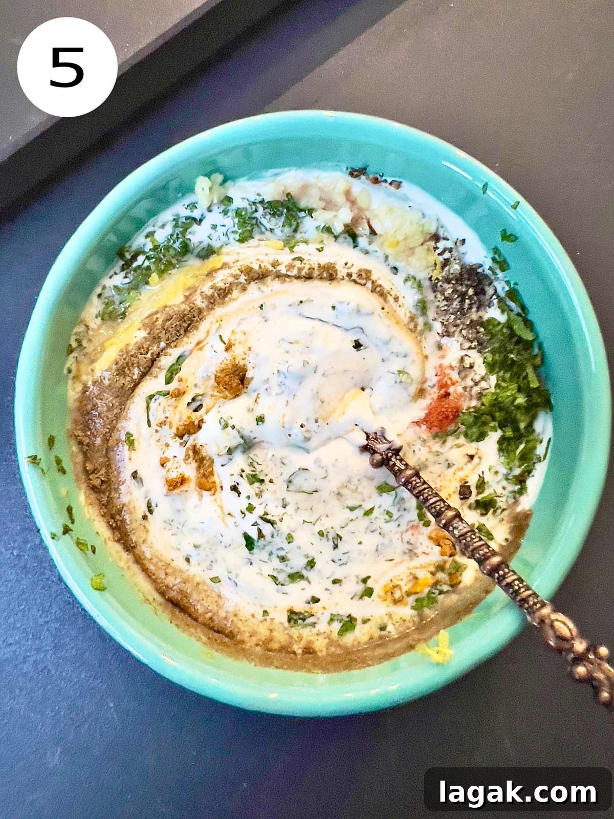 Mint and yoghurt sauce being mixed up.