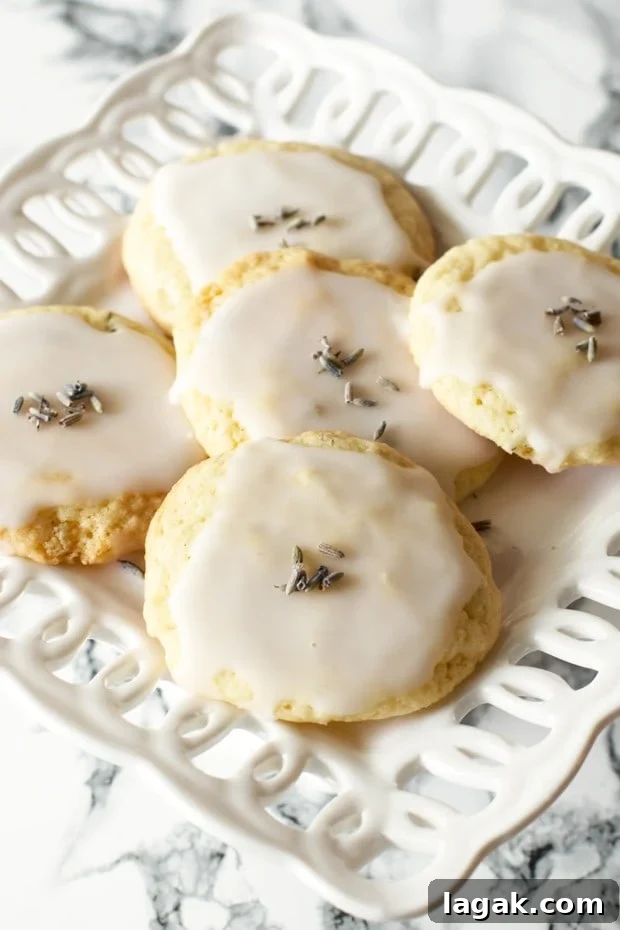 Grandma’s Lavender Cookie Recipe — Soft Floral Shortbread 3 Golden lavender cookies glazed and sprinkled with edible dried lavender, arranged neatly on a white serving platter.