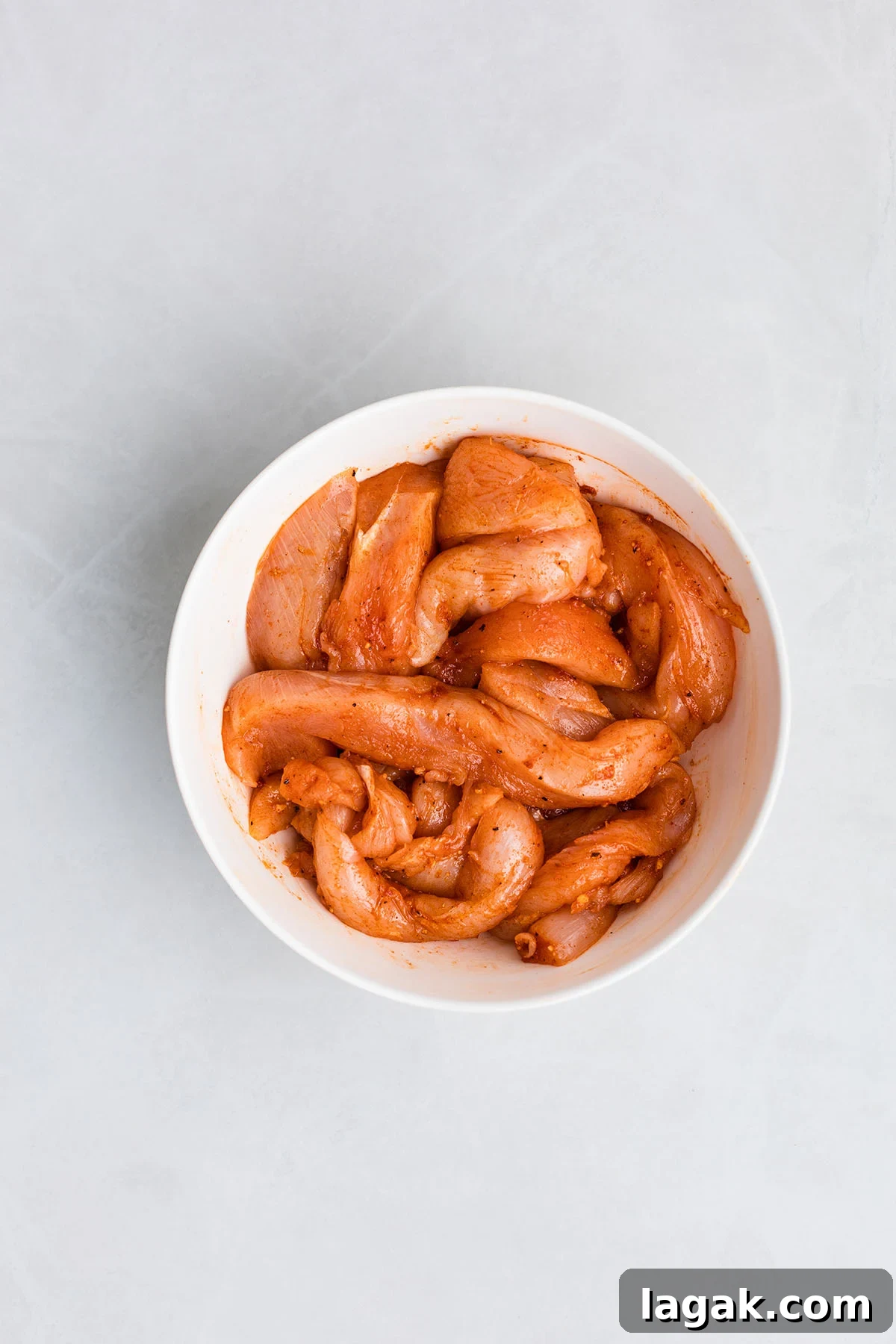 Honey Mustard Chicken Wrap Recipe: Quick Flavorful Lunch Idea 5 Seasoned raw chicken in a bowl.