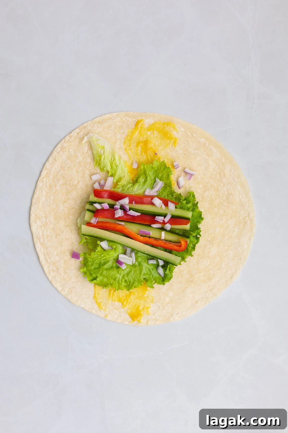 Honey Mustard Chicken Wrap Recipe: Quick Flavorful Lunch Idea 9 Flour tortilla with honey mustard sauce, lettuce, red peppers, cucumbers, and red onion.