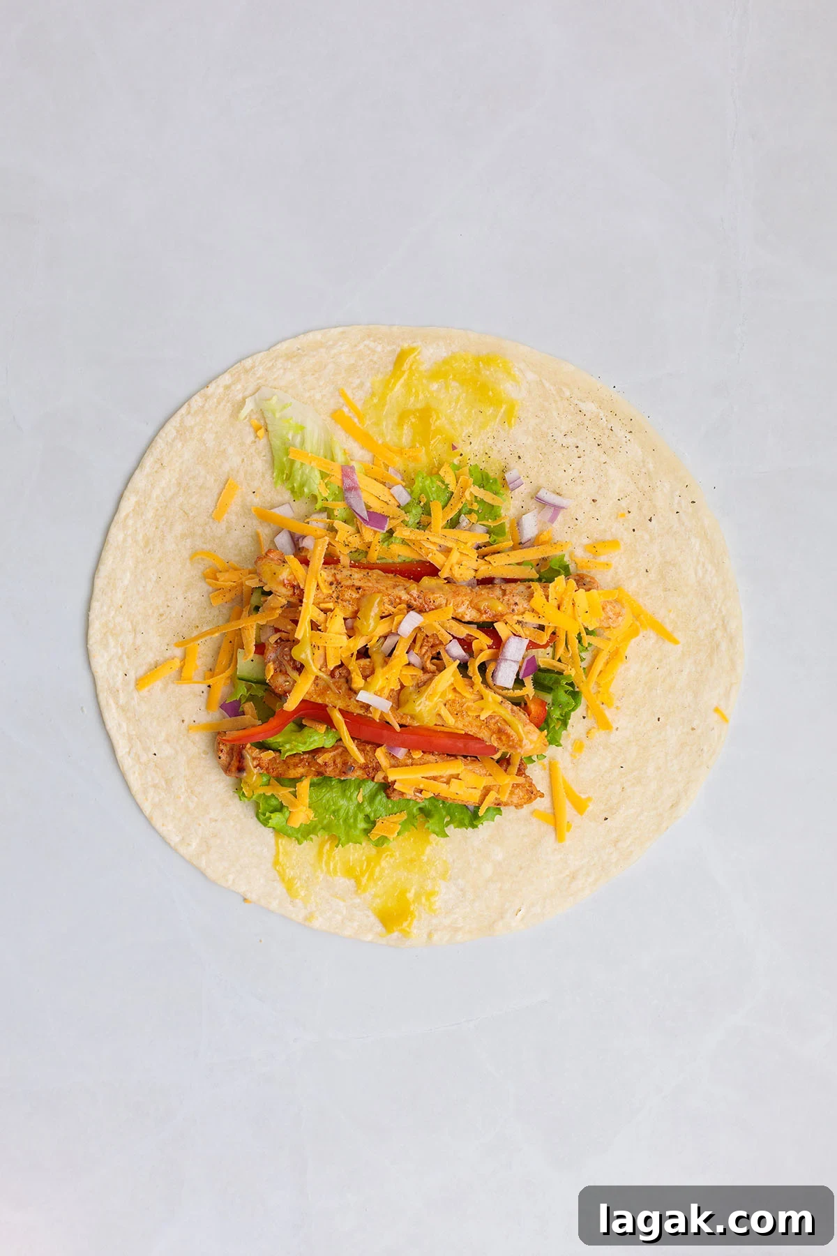 Honey Mustard Chicken Wrap Recipe: Quick Flavorful Lunch Idea 10 Honey mustard sauce, lettuce, red peppers, cucumbers, red onion, cheese, and chicken layered in a flour tortilla.