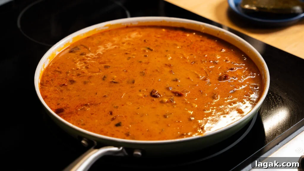 Smoky Creamy One-Pan Chickpea and Rice Skillet Recipe 5 Building the sauce for a chickpeas and curry dish.