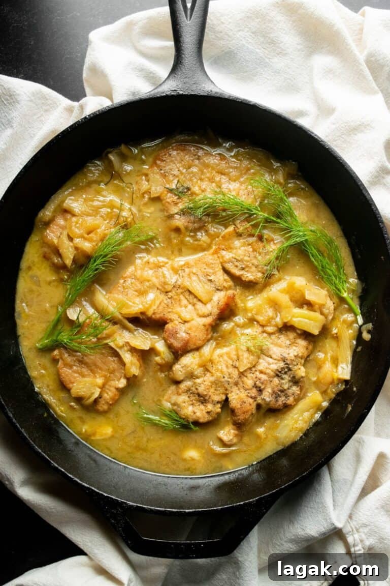 pork chops in a skillet in fennel dijon sauce.