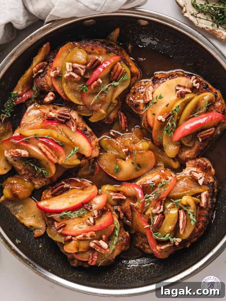 pork chops with applies in a frying pan.