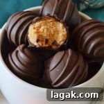 No-Bake Peanut Butter Balls Recipe for Quick Homemade Treats 5 a small ceramic white bowl filled with peanut butter truffles, one truffle has a bite missing from it