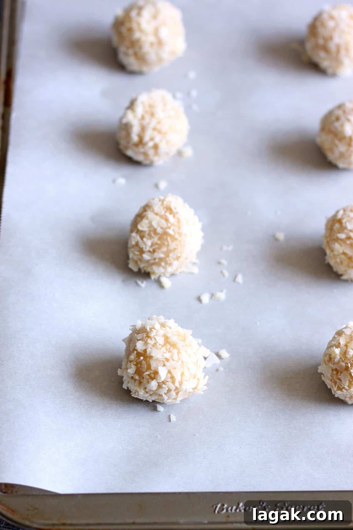 Guava Cookie Recipe: Crispy, Fruity Baked Cookies 5 Guava cookie dough balls rolled in coconut on a baking sheet.
