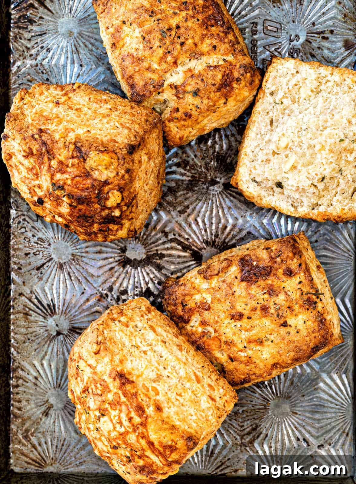 Close up on flaky cheese sourdough biscuits on a metal baking tray