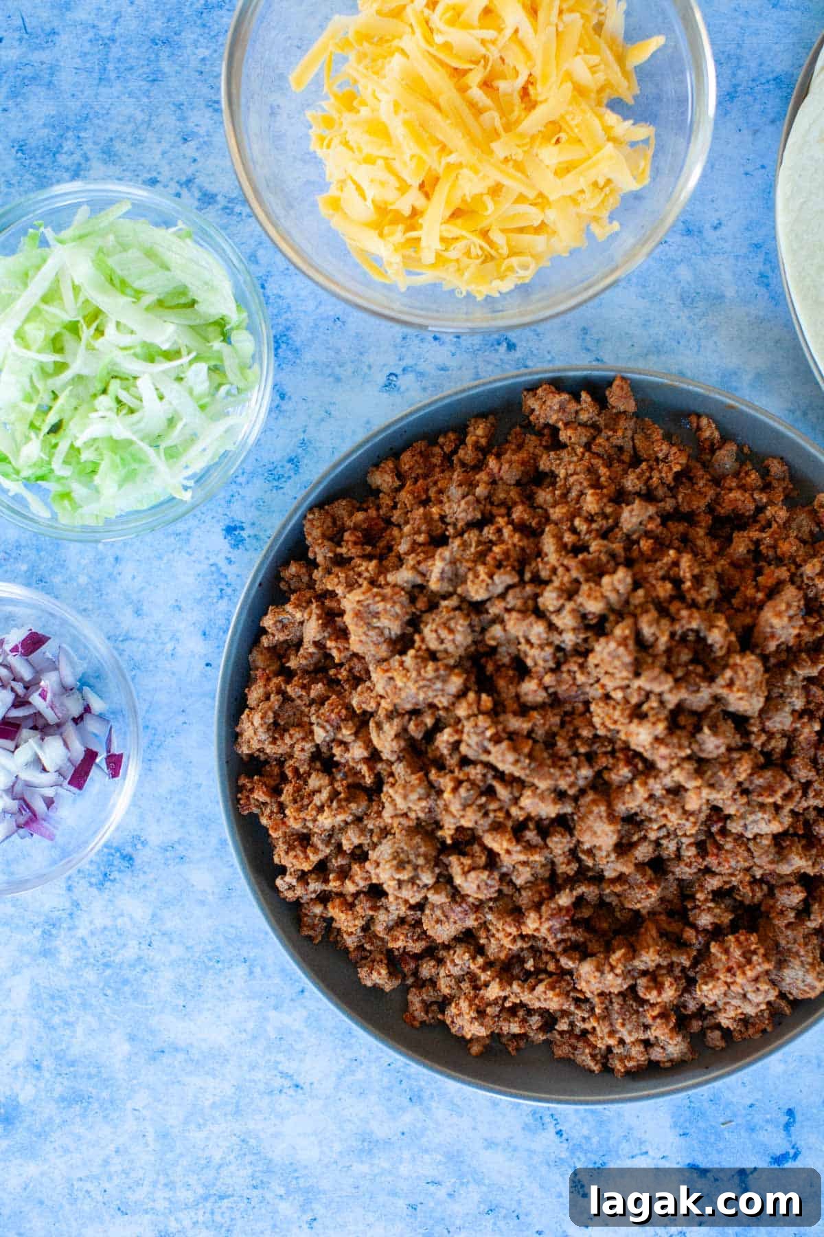 Authentic Ground Beef Tacos Recipe for Weeknight Dinners 3 Ingredients for ground beef tacos on a blue countertop.