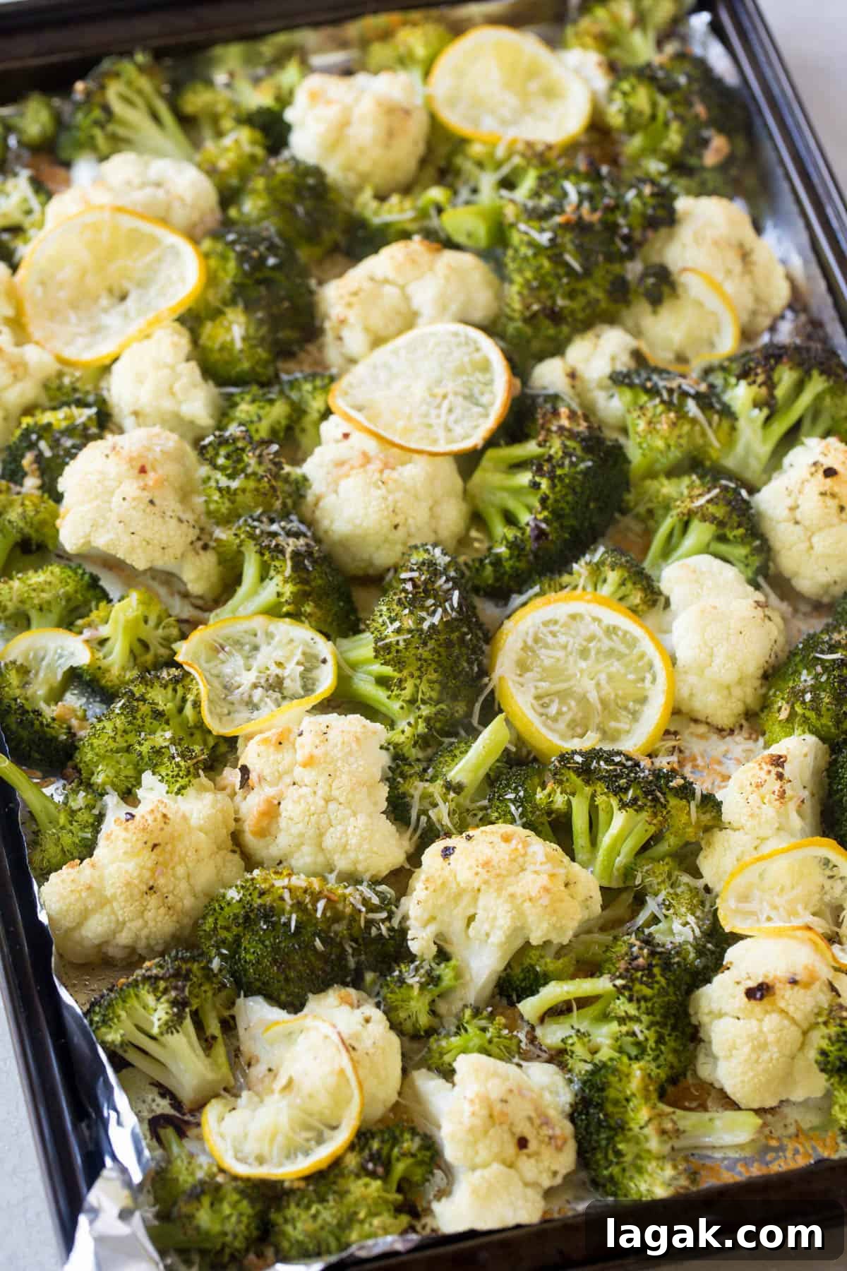 Crispy Roasted Broccoli & Cauliflower with Parmesan and Lemon 3 Crispy roasted cauliflower and broccoli on a sheet pan with grated cheese sprinkled on top.