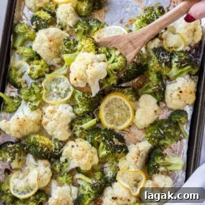 Crispy Roasted Broccoli & Cauliflower with Parmesan and Lemon 5 A spoon scooping roasted broccoli and cauliflower off the pan.