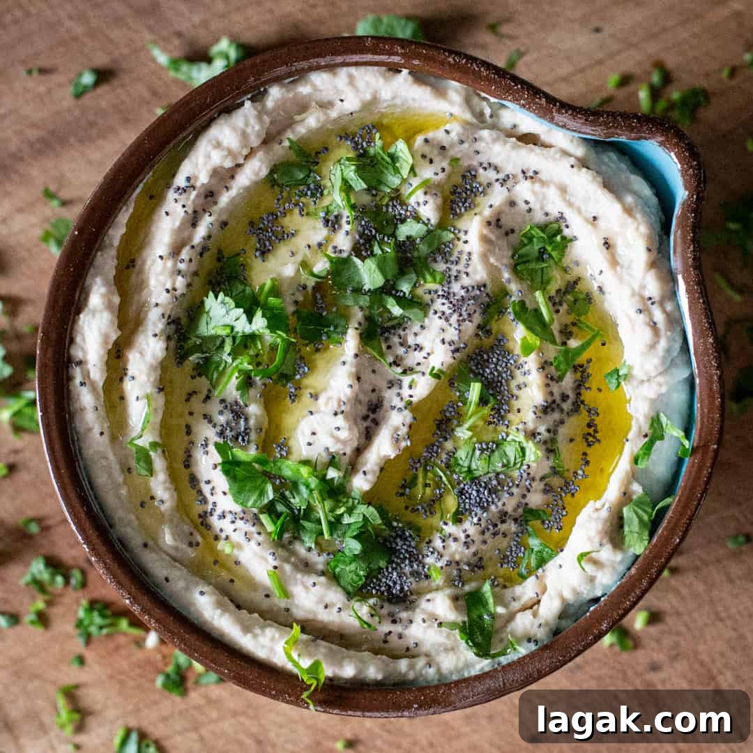 Creamy Vegan Butter Bean Dip — Protein-Packed Snack Recipe 15 Overhead shot of creamy bean dip in brown bowl on wooden chopping board