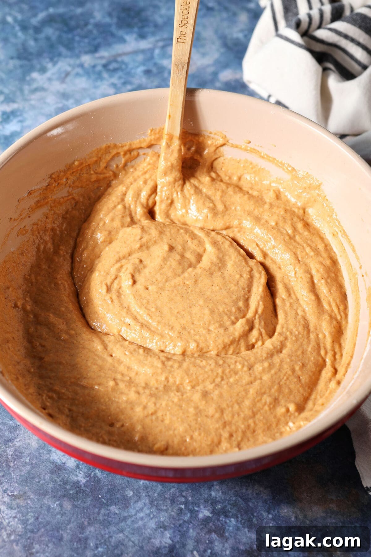 Pumpkin Waffles with Cinnamon Maple Syrup Recipe 8 Pumpkin waffle batter in a bowl on a dark blue surface