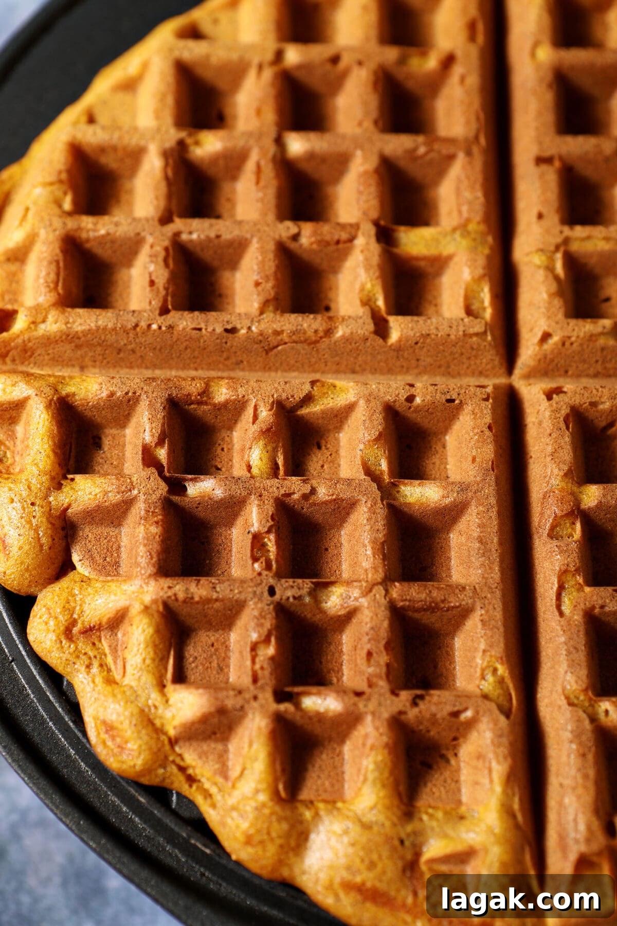 Pumpkin Waffles with Cinnamon Maple Syrup Recipe 9 Close up of a pumpkin waffle in a waffle iron