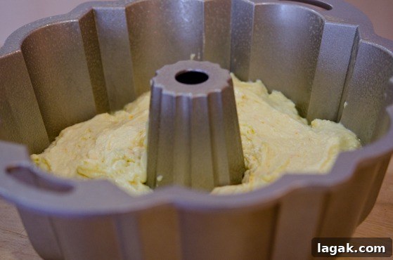tutorial_-8 Orange cake batter is panned in a greased bundt pan.