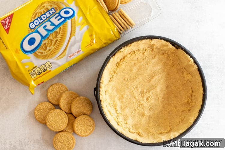 golden oreo crust in springform pan next to cookies
