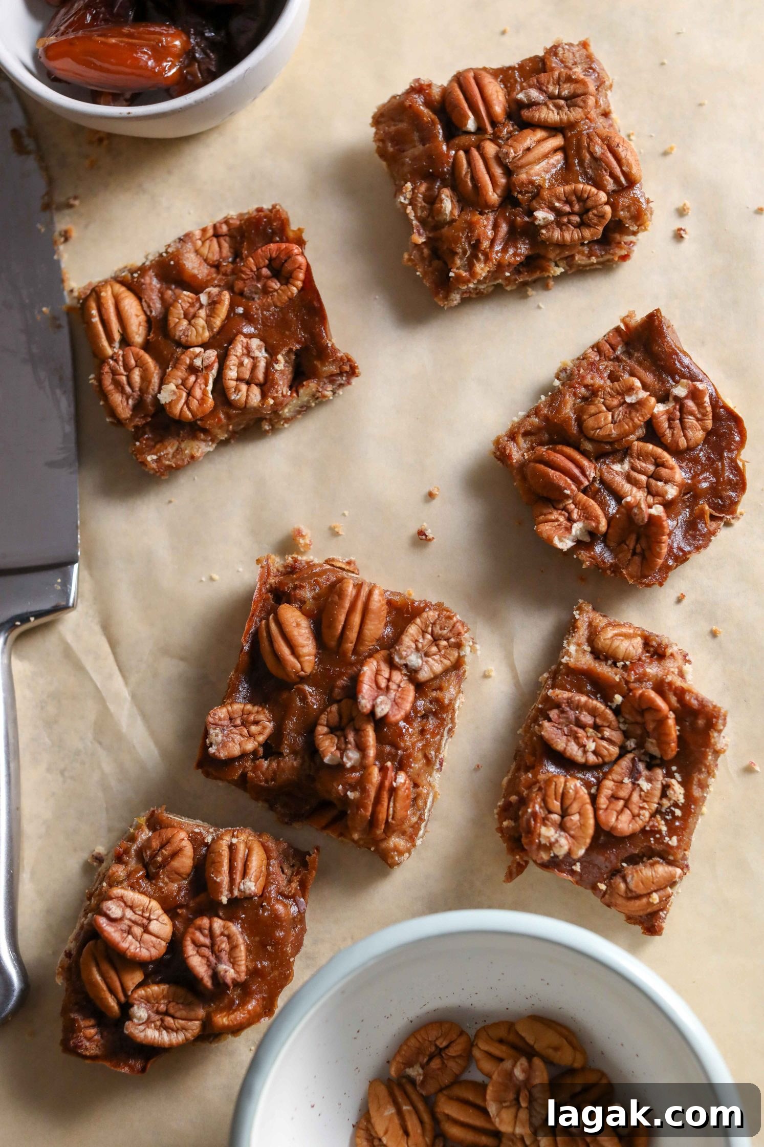 Chewy Pecan Pie Bars with Buttery Shortbread Crust 2 Vegan Pecan Pie Bars sliced on parchment paper with knife by Flora & Vino