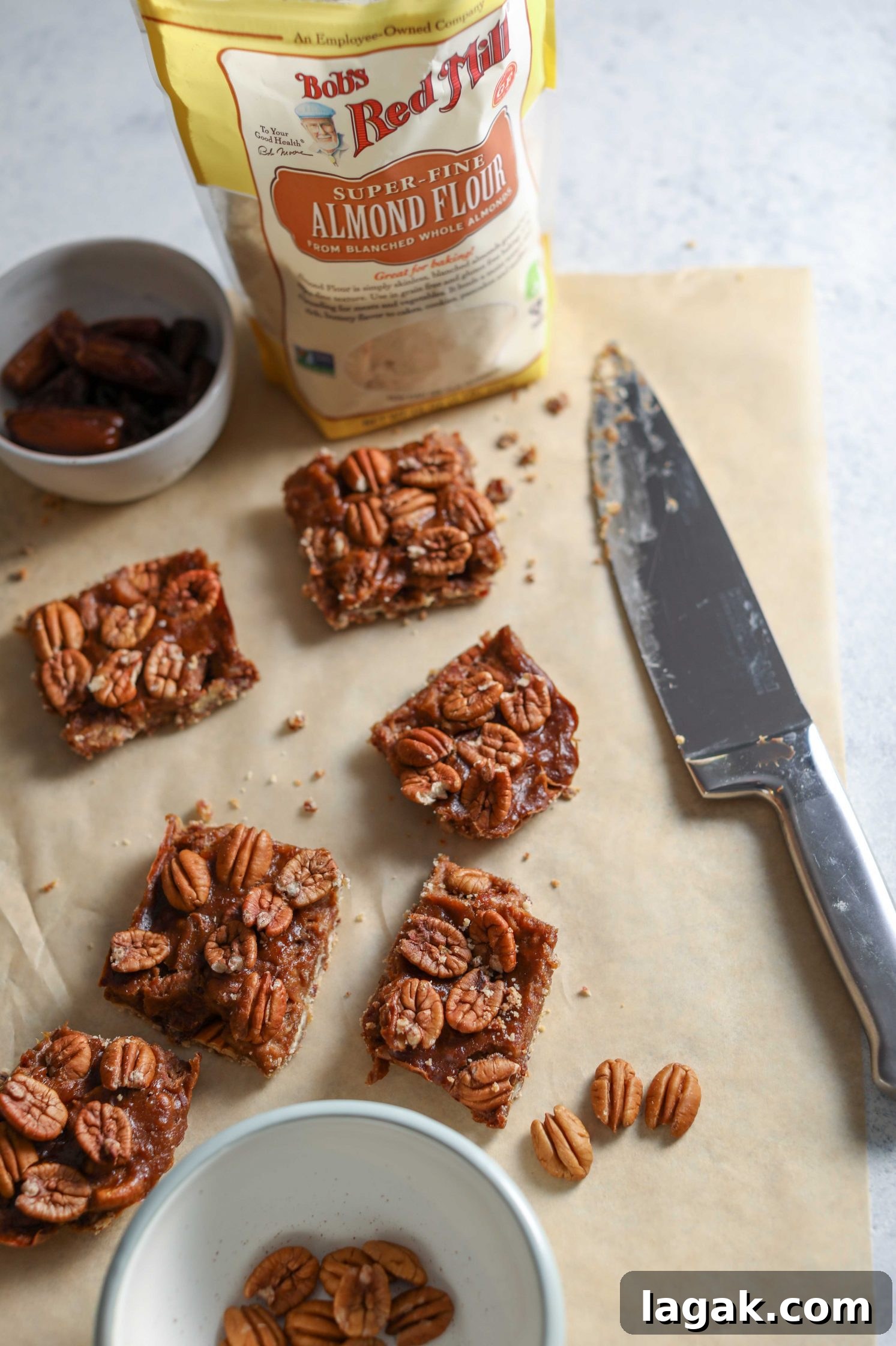Chewy Pecan Pie Bars with Buttery Shortbread Crust 8 Vegan Pecan Pie Bars sliced on parchment paper with knife by Flora & Vino