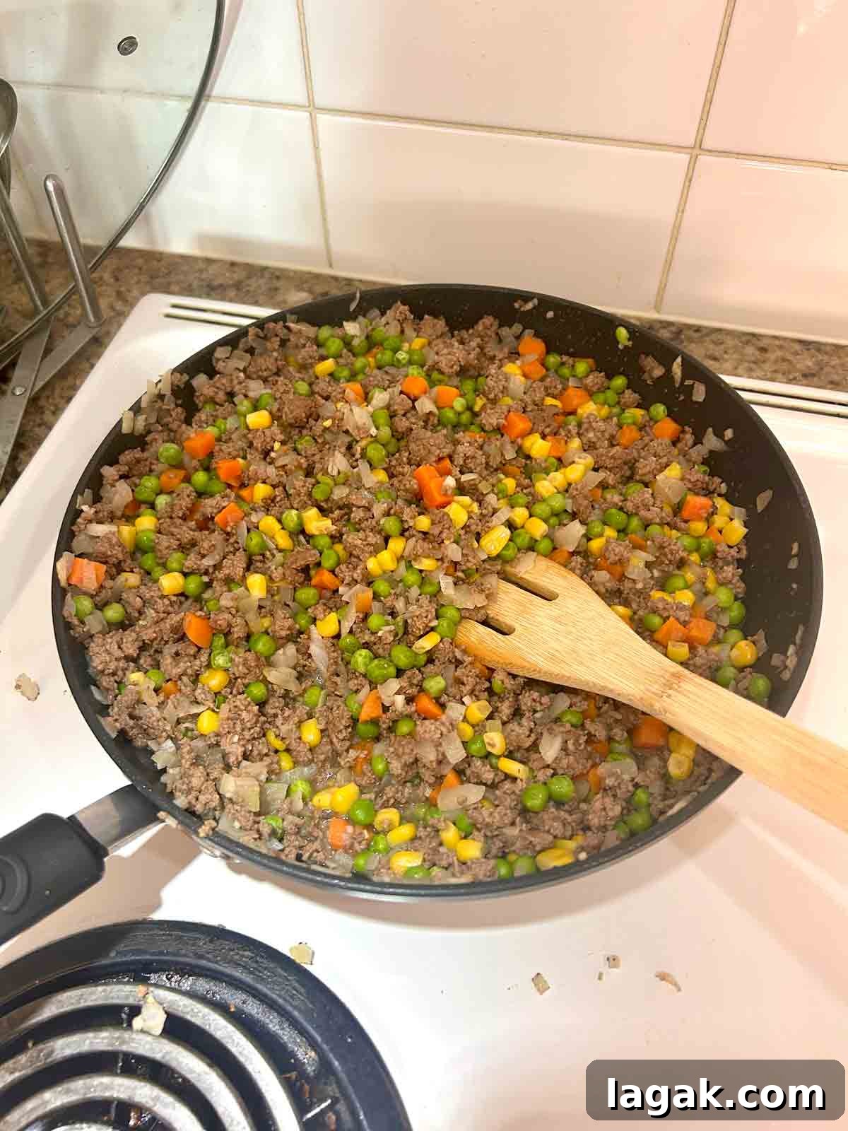 add mixed vegetables to ground beef, garlic, and onion.