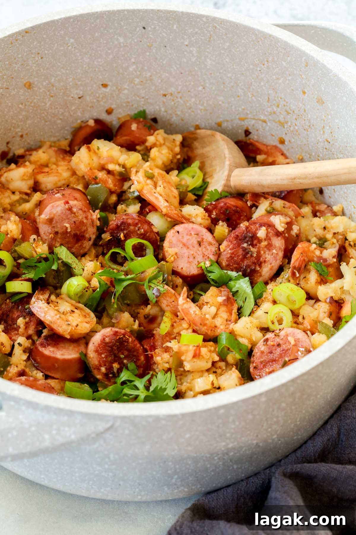Having a Whole30 jambalaya recipe in your recipe box means never missing out on these amazing traditional Louisiana flavors. Make a few small changes and enjoy this southern comfort food while maintaining your diet. overhead view of a white pot of whole30 jambalaya