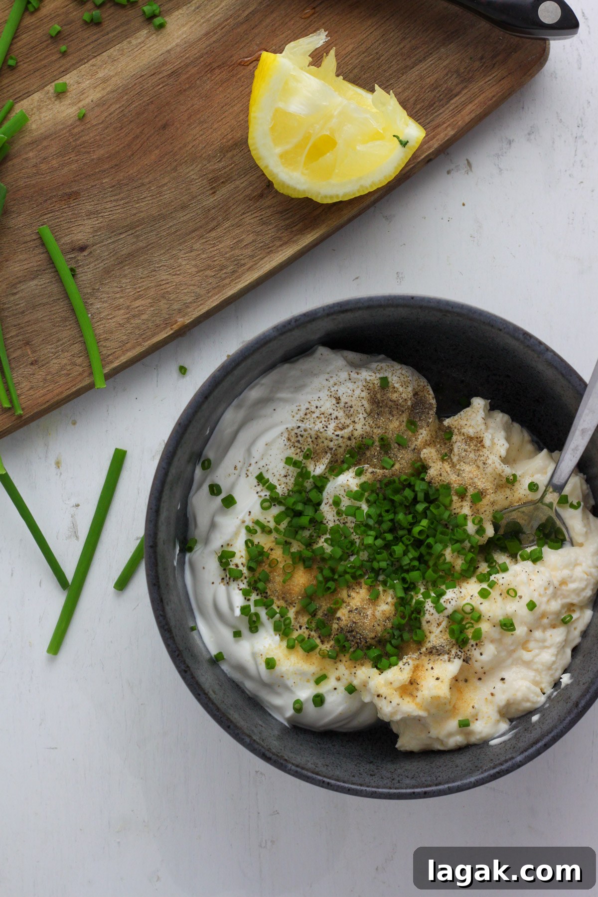 Creamy Sour Cream & Chive Dip Recipe for Parties 5 A blue bowl with sour cream and onion dip unstirred.
