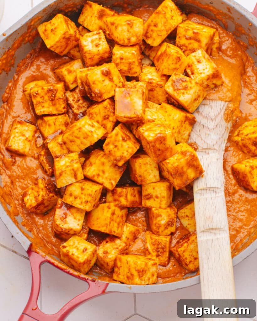 Homemade Paneer: Step-by-Step Recipe for Fresh Indian Cheese 3 How to Make Paneer at Home photo of paneer in a pan with sauce.