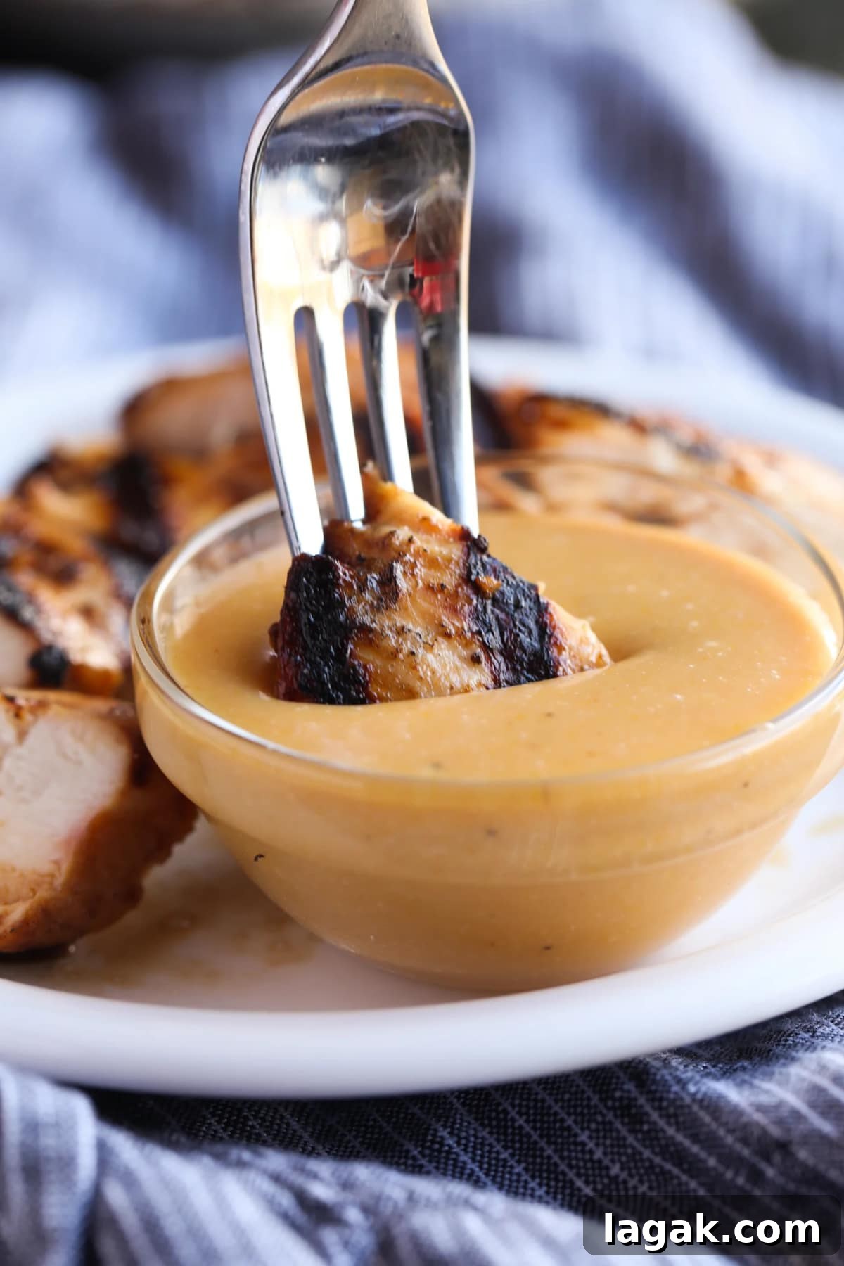 This Chick Fil A Sauce recipe is the BEST Chicken Dipping Sauce! Smoky, sweet, with a slight tang, it's PERFECT for dipping chicken nuggets, grilled chicken, or french fries! Dunking a piece of grilled chicken into a small bowl of homemade Chick-Fil-A Sauce using a fork