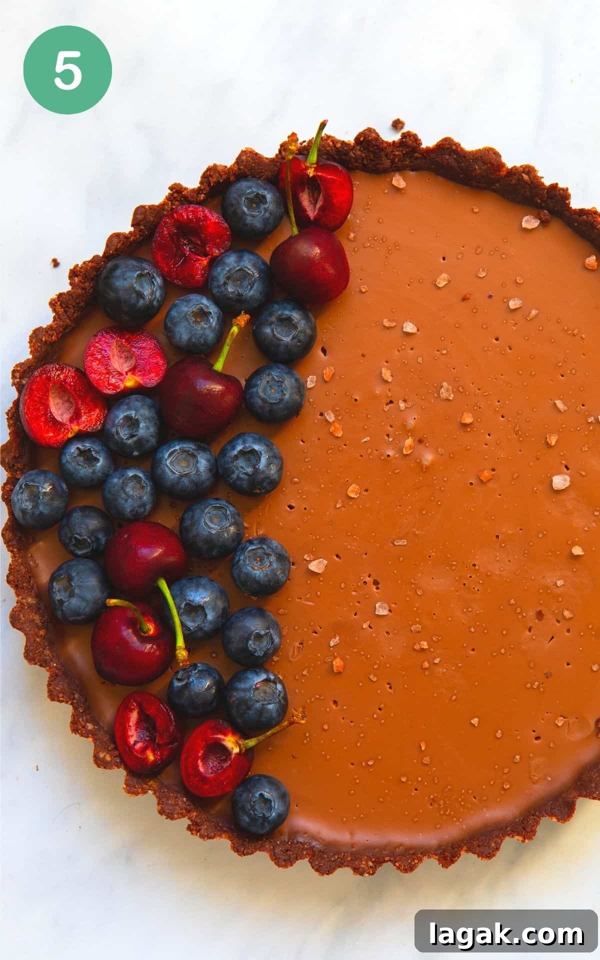 Decadent Vegan Chocolate Tart Recipe for Rich, Creamy Desserts 8 Overhead image of a vegan chocolate tart with fresh berries on top and flakey salts.