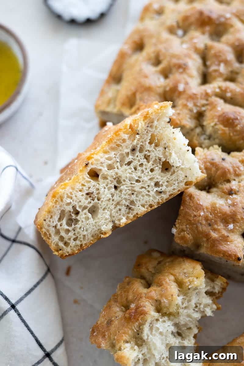 Black Pepper Focaccia Recipe: Crispy Crust & Aromatic Crumbs 2 A side view of a slice of Black Pepper Focaccia with bubbly air pockets.