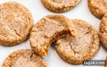 Brown butter sugar cookies on top of a baking sheet with a bite missing out of one showing off chewy texture.