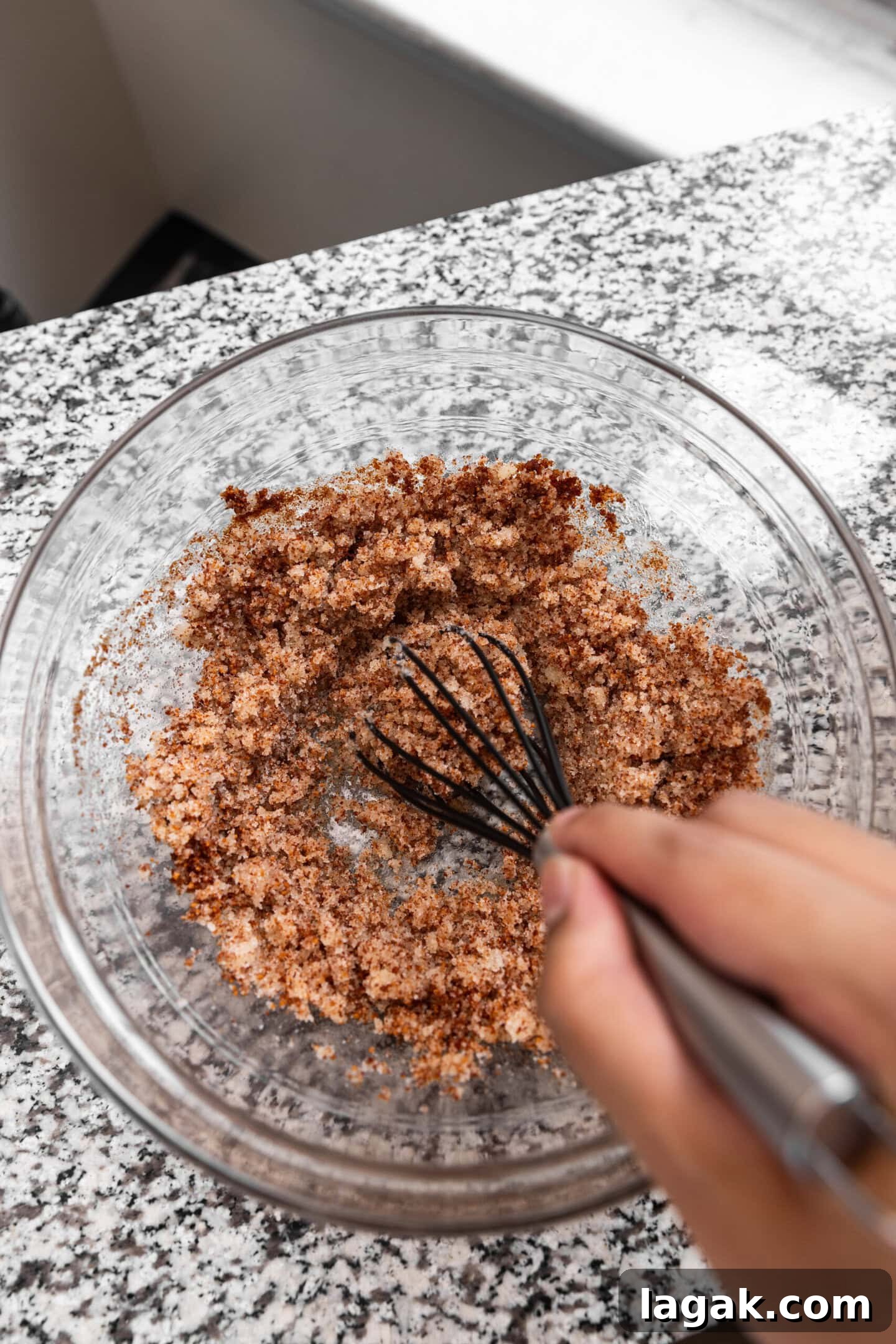 Sugar being whisked into the brown butter mixture.