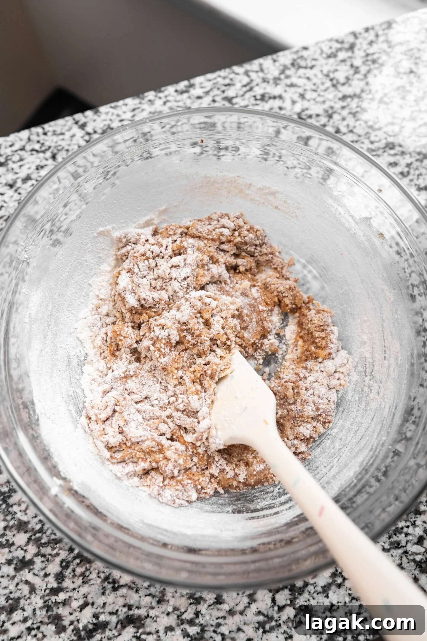 Dry ingredients being folded into the wet ingredients to form the brown butter sugar cookie dough.