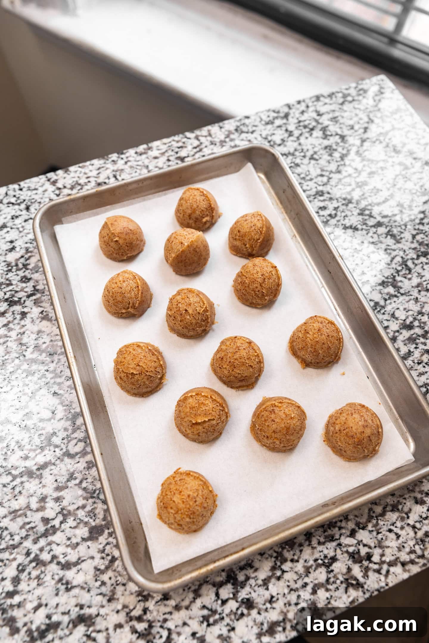 Brown butter sugar cookie dough balls spaced out on a baking sheet.