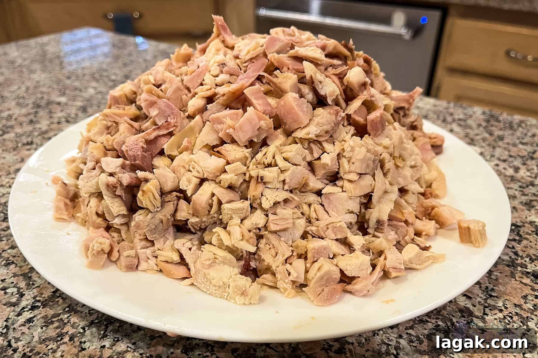 How to Cut and Shred Rotisserie Chicken: Portioning & Freezing Tips 9 A pile of roughly diced rotisserie chicken on a plate.