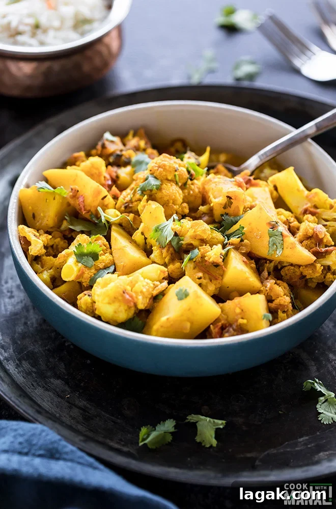Instant Pot Aloo Gobi: Quick Spiced Potato & Cauliflower Curry 2 bowl of aloo gobi with a spoon and bowl of rice in the background
