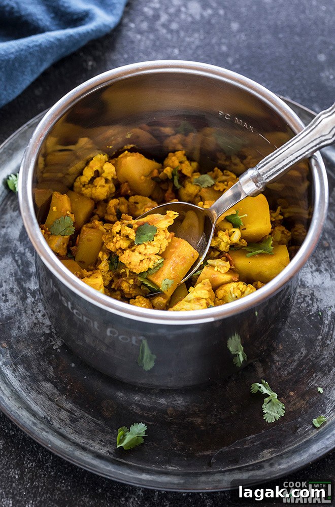 Instant Pot Aloo Gobi: Quick Spiced Potato & Cauliflower Curry 3 Aloo Gobi in Instant Pot with a spoon