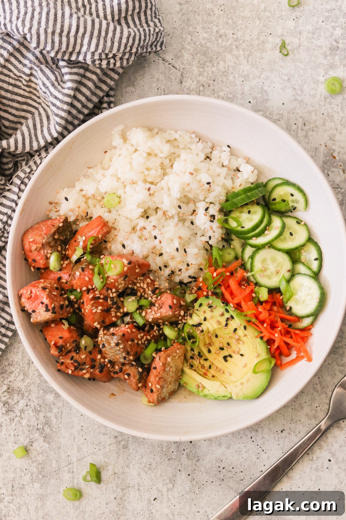 Crispy Air Fryer Teriyaki Salmon Recipe in 20 Minutes 5 an overhead shot of a bowl of rice topped with salmon, cucumbers, carrots, and avocado