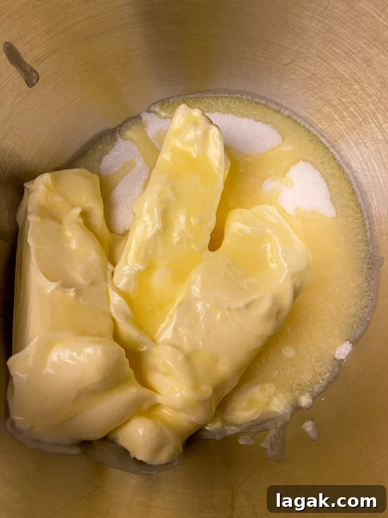 Softened butter on top of granulated sugar in a mixing bowl