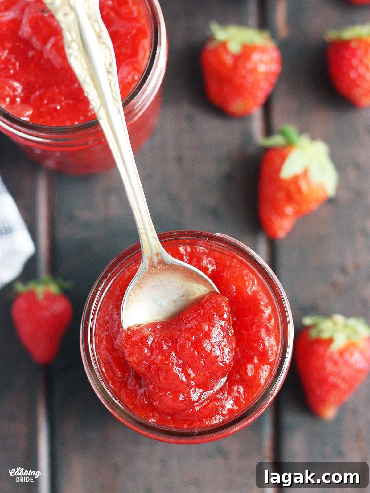 Strawberry Jam Recipe with Pectin: Smooth, Spreadable Preserves 11 tarnished gold spoon dipping out a bite of strawberry jam from a jar