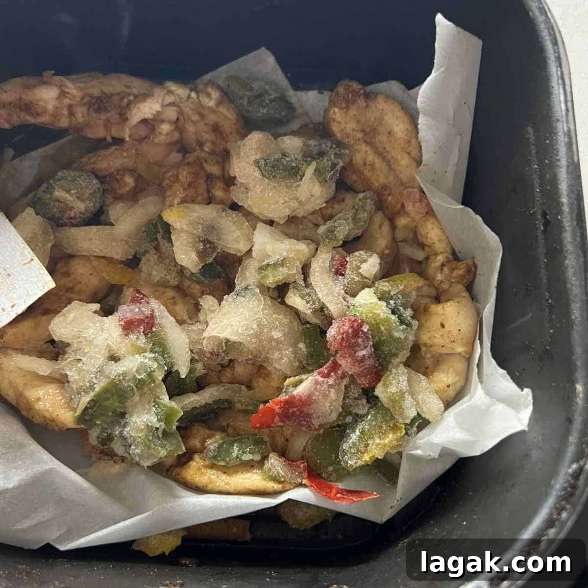 Crispy Air Fryer Chicken Fajitas Recipe — Quick Weeknight Meal 5 Frozen vegetables and fajita chicken in an air fryer basket.